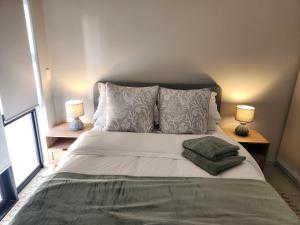 a bedroom with a large bed with two lamps at Beach Haus Unit 1 in Cape Town