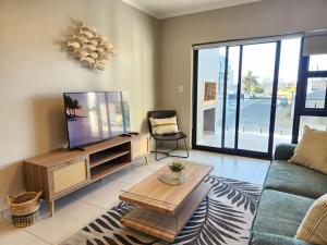 a living room with a couch and a tv at Beach Haus Unit 1 in Cape Town