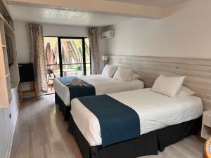 a hotel room with two beds and a balcony at Hotel Palmas de La Serena in La Serena +28 photos