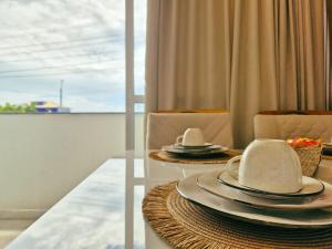 a dining room with a table with plates and hats on it at Airport subway apartment in Lauro de Freitas