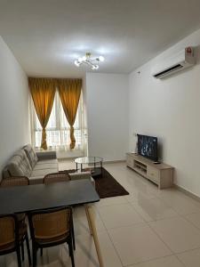 a living room with a couch and a tv at QH Guesthouse in Shah Alam