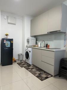 a kitchen with a sink and a washing machine at QH Guesthouse in Shah Alam