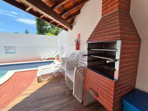 a patio with a brick oven next to a swimming pool at Airport subway apartment in Lauro de Freitas