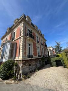 a large brick building with aventh floor at La HALTE des CAVALIERS in Compiègne