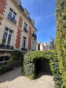 an ivy covered garage in front of a building at La HALTE des CAVALIERS in Compiègne