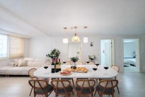 a white living room with a white table and chairs at stay young in Suwon