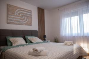 a bedroom with a large bed with towels on it at Apartman VALE in Županja