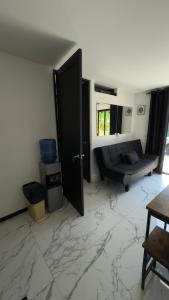 a room with a door and a couch and marble floor at Casa Benedicion in Pavones
