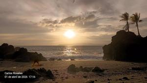 a person walking on the beach at sunset at Casa Benedicion in Pavones