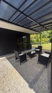 a patio with a table and chairs under a roof at Casa Benedicion in Pavones
