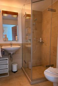 a bathroom with a shower and a sink at Soami Spaces - Alpine Hideaway in Millstatt