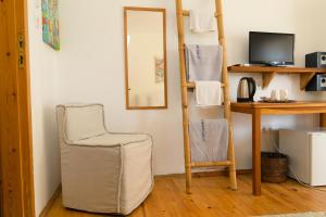 a room with a ladder and a chair and a mirror at Lilium Rooms in Çeşme