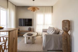 a living room with a couch and a table at Cavo Dio 8 - Beachfront bliss - Cozy Apt Pool Sunset in Káto Dhiminión