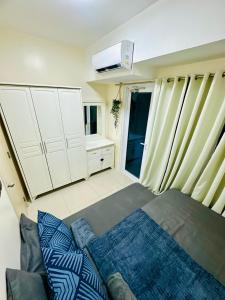 a bedroom with a bed and a air conditioner at Aeva's Cozy Stays in Manila