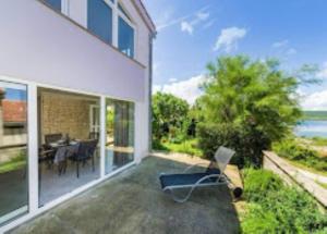 a house with a patio with a table and chairs at Apartman Tonko in Novigrad Dalmatia