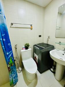 a bathroom with a toilet and a sink at Aeva's Cozy Stays in Manila