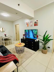 a living room with a television and a table at Aeva's Cozy Stays in Manila +8 photos