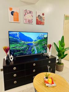 a living room with a television on a dresser at Aeva's Cozy Stays in Manila