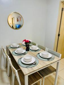 a dining room table with chairs and a mirror at Aeva's Cozy Stays in Manila