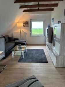 a living room with a couch and a tv at Huus Diekblick Ditzum in Bunde +10 photos