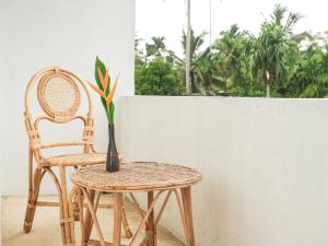 a table and a chair and a vase with a plant at Studio K Ahangama in Ahangama