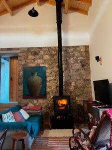 a living room with a stone wall with a fireplace at Casa da Curva in Mendiga