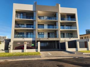 an apartment building with a fence in front of it at Beach Haus Unit 1 in Cape Town