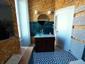 a bathroom with a sink and a mirror at Maison Tyto Alba in Saint-Victurnien