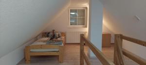 a staircase with a bed and a chair in a room at Haus Seeblick in Jettingen-Scheppach