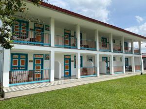 a large building with blue doors and windows and grass at Finca Hotel Valparaíso in Armenia