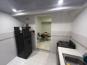 a kitchen with a black refrigerator and a table at Apartamento 201 amplio cómodo in Cali
