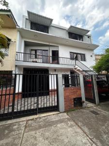 a white house with a black fence at Apartamento 201 amplio cómodo in Cali
