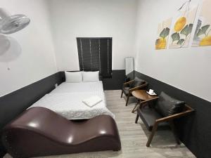 a small bedroom with a bed and a chair at Hotel Đông Ngô Biên Hòa in Ấp Thành