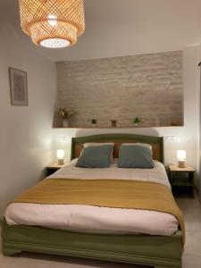 a bedroom with a large bed with two pillows at Ô Ptit Verger in Coulon