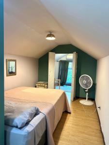 a bedroom with a bed and a fan at CASA STELLA in Heredia