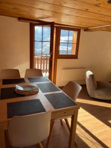 a dining room with a table and chairs and windows at Appartement entier dans chalet traditionnel in Bratsch