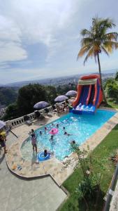 a group of people in a swimming pool with a water slide at Casa das Luzes Hostel IVN in Rio de Janeiro