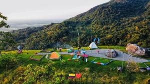 a group of tents in a field with a mountain at Aparta Hotel La Osadía in Acacías