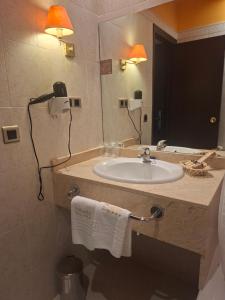 ein Badezimmer mit Waschbecken und Spiegel in der Unterkunft Hotel Oriente in Teruel + 50 Fotos
