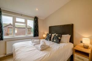 a bedroom with a large white bed with a window at Field View 2 bed 'S'- Spruce in Eye