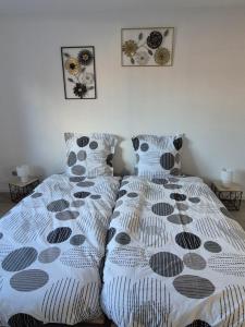 a bedroom with two beds with white comforter at Le repaire des Manalas in Ingersheim