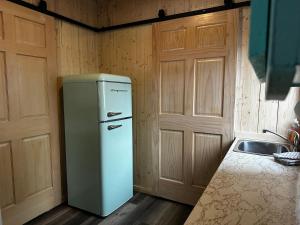 a kitchen with a refrigerator and a sink at Chalets Memphrémagog in Magog-Orford
