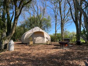 a white tent in a field with trees at The Warren, Hot Tub and wood burning stove in Brackley