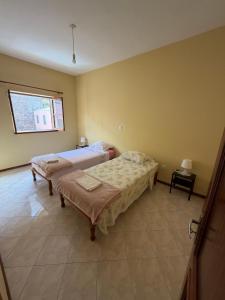 a bedroom with two beds and a window at Apartamento Rua de Horta in Ribeira Grande +13 photos