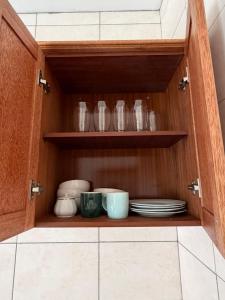 a cupboard with plates and glasses in it at Apartamento Rua de Horta in Ribeira Grande