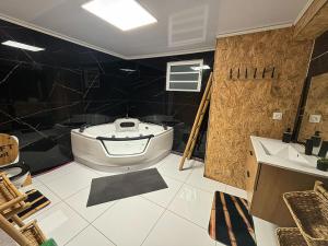 a bathroom with a tub and a toilet and a sink at Ti case ali in Saint-Benoît
