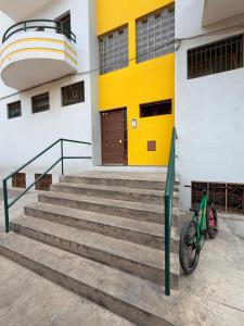 a bike parked in front of a building with a yellow door at Apartamento Rua de Horta in Ribeira Grande
