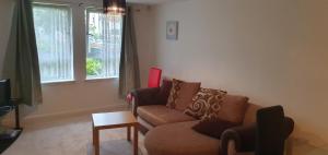 a living room with a couch and a table at Spacious 2-Bedroom Ground Floor Flat with 2 Double Beds, Sleeps 4 in Central Aberdeen in Aberdeen