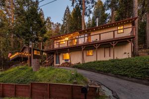 a house in the woods with a driveway at Enchanted Pines in Twain Harte