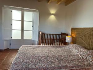 a bedroom with a large bed and a window at Marvão Country Houses - Queixos II in Santo António das Areias +15 photos
